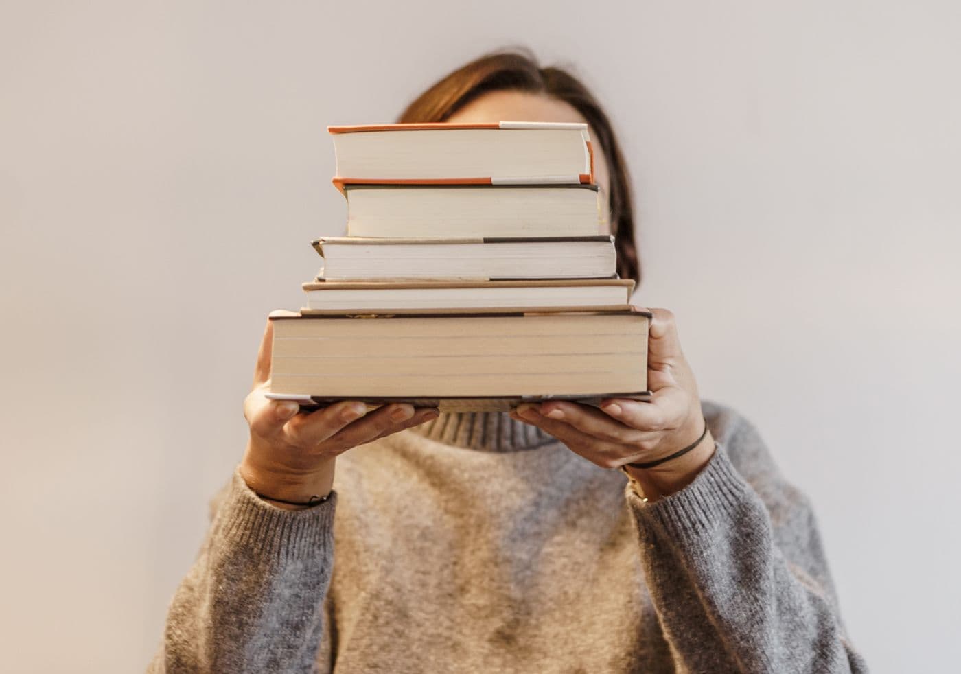Person holding a stack of books
